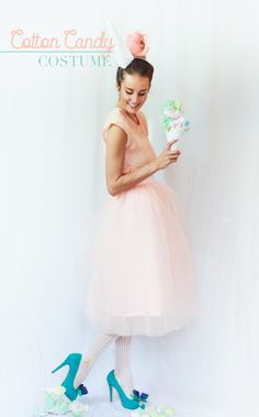 a woman in a pink dress is holding a cupcake and wearing blue high heels