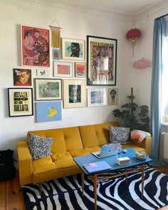 a living room filled with furniture and lots of pictures on the wall above it's coffee table