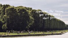 people are sitting on the grass near trees and water with a message written in it