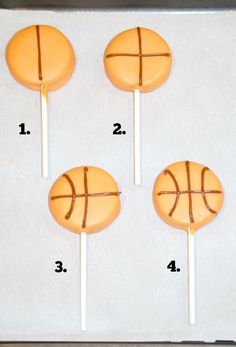 four basketball shaped lollipops sitting on top of a baking sheet with measurements