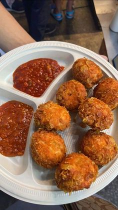 a white plate topped with meatballs covered in sauces and ketchup on top of a table