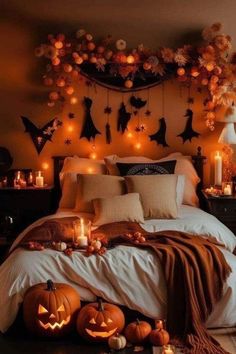 a bedroom decorated for halloween with pumpkins, candles and decorations on the wall above the bed