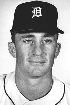 a black and white photo of a baseball player wearing a hat with the detroit tigers on it