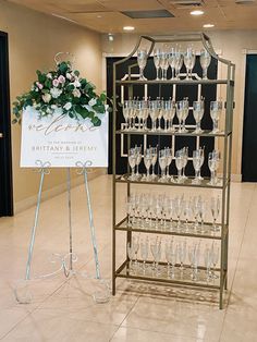 there is a sign that has wine glasses on it and flowers in the vases