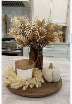 a table topped with a vase filled with flowers and a candle on top of it