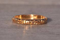 The Gromo: Antique Yellow Gold Hand Engraved Mid Finger or Child's Ring. The ring features a scrolled pattern throughout and is perfect for a child or mid-finger ring. The ring is crafted in yellow gold and is a finger size 1.25. Love this piece, but don't have the money to spend right now? We offer FREE layaway on every item in our shop. With just 20% down, take one full year (interest-free) to pay off your new jewelry! There are no hidden fees or charges, ever. For more information on our laya Ornate Yellow Gold Engraved Ring As Gift, Ornate Engraved Yellow Gold Ring As Gift, Antique Adjustable Rings With Intricate Design, Antique Adjustable Engraved Rings, Antique Adjustable Etched Ring, Antique Adjustable Etched Rings, Gold Engraved Stackable Heirloom Rings, Gold Etched Band As Gift, Gold Etched Bands As Gift