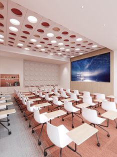 an empty classroom with desks and chairs in front of a large screen on the wall