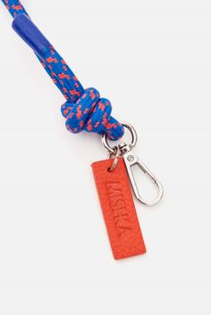 an orange and blue rope with a red tag on it is attached to a keychain