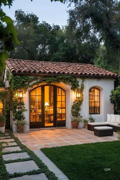 an outdoor patio with seating and potted plants on the side, surrounded by greenery