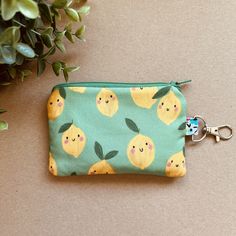 a small zipper bag with lemons on it and a keychain hanging from the front