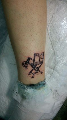 a tattoo on the leg of a person with a chair