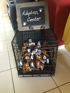 small stuffed animals in a metal cage with a sign on the top that says adoption center