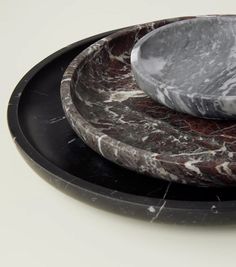 two marble plates stacked on top of each other with one plate in the middle and another bowl at the bottom