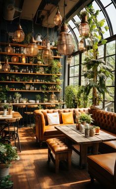 a room filled with lots of plants next to a wooden table and couches in front of large windows