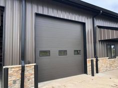 an industrial style garage with two doors and windows