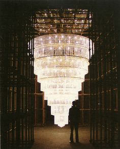 a person standing in front of a large chandelier