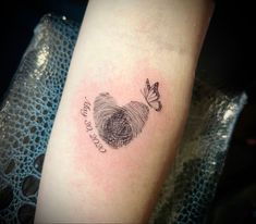 a small tattoo on the arm of a woman with a fingerprint and butterfly in it