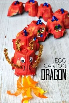 an egg carton dragon made out of orange paper and gold glitters on it