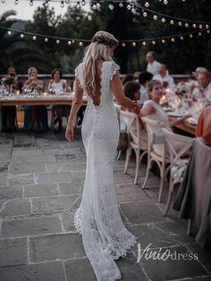 the back of a woman's dress as she walks through an outdoor dining area