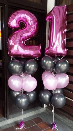 the number twenty two is made out of balloons and some silver and pink are in front of it