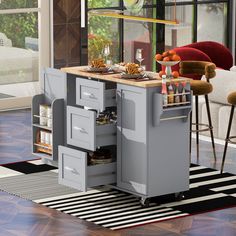 a kitchen island with two drawers and an open drawer in the middle on a striped rug