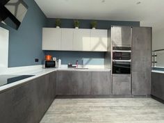 a kitchen with white cabinets and blue walls