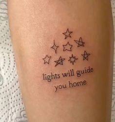 a tattoo saying lights will guide you home on someone's leg with five stars