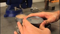 a person using a grinder to make something out of a metal can on top of a workbench