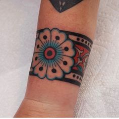 a woman's arm with a flower tattoo on the left side of her wrist