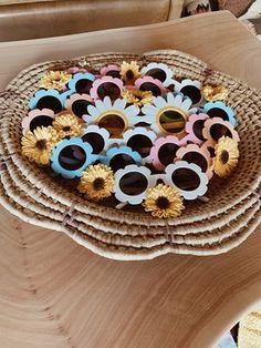 there are many sunglasses on top of each other in the basket with sunflowers