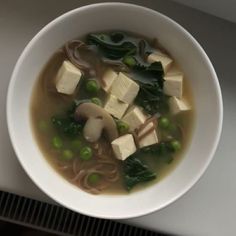 a white bowl filled with soup and tofu