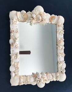 there is a mirror made out of seashells on the wall