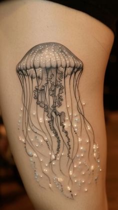 a woman's thigh with a jellyfish tattoo on it