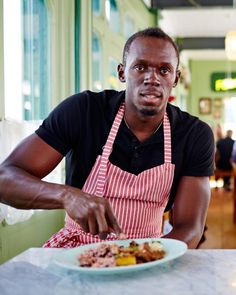 a man sitting at a table with a plate of food in front of him,