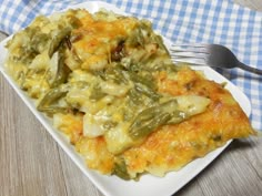 a white plate topped with green bean casserole next to a knife and fork