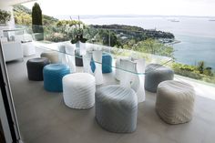 a room with many different colored stools and tables on the floor next to an ocean view