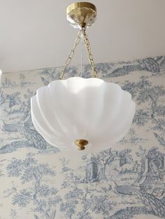 a chandelier hanging from the ceiling in a room with blue and white wallpaper