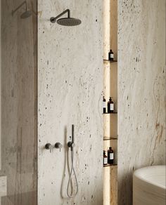 a bathroom with a tub, shower head and shelves on the wall next to it