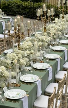 a long table is set with white flowers and candles