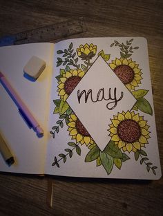 an open notebook with sunflowers and the word may written in cursive writing