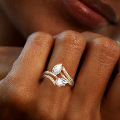 a woman's hand with two diamond rings on it