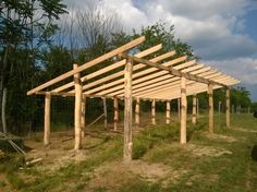 a wooden structure sitting in the middle of a field