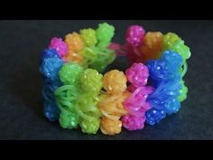 there are many different colored bracelets on the black surface, one is made out of plastic beads