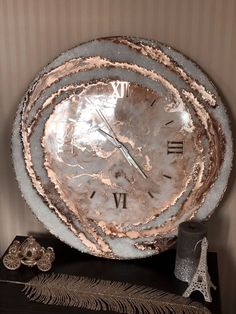 a clock that is sitting on top of a table next to a vase and other items