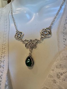 Here's a beautiful Celtic knot bib necklace with fancy flourish bib and a sterling silver set deep green faceted chrome diopside. It can be worn more as a bib or longer and is adjustable.  Chrome Diopside is a gemstone that can rival a fine quality Tsavorite and even a fine quality Columbian Emerald in beauty and intensity of shade. This one has a very deep green color. Celtic knots are known for their never-ending lines signifying eternal love and friendship and life. They're found in ancient texts and are a popular style for Irish and Celtic jewelry. Thank you for visiting, and have fun browsing. I hope you find something that will make you happy or a gift for someone special.  Don't forget you can always buy for yourself because getting great jewelry in the mail any day is a great day! Columbian Emeralds, Celtic Knots, Silver Chrome, Irish Celtic, Bib Necklaces, Celtic Jewelry, Green Gemstones, Bib Necklace, Friendship Gifts