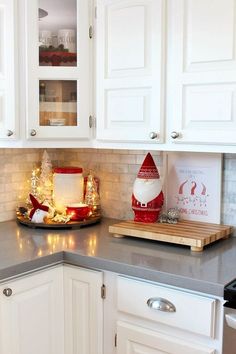 a kitchen counter with white cabinets and christmas decorations on the counter top in front of it