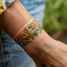 a woman's arm with a flower tattoo on the left side of her wrist