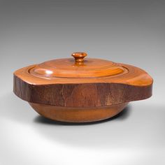 a wooden bowl with a lid sitting on a table