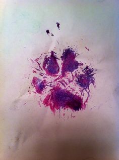 a piece of paper with purple ink splattered on it and two birds in the background