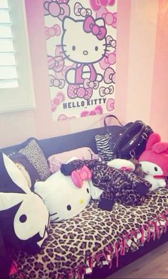 hello kitty stuffed animals are sitting on a leopard print couch in front of a hello kitty poster